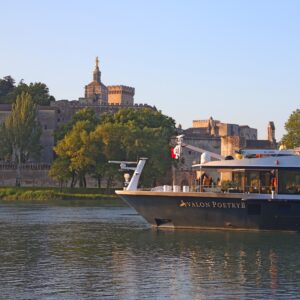 The Avalon Poetry II sailing on a river, with a castle in the background